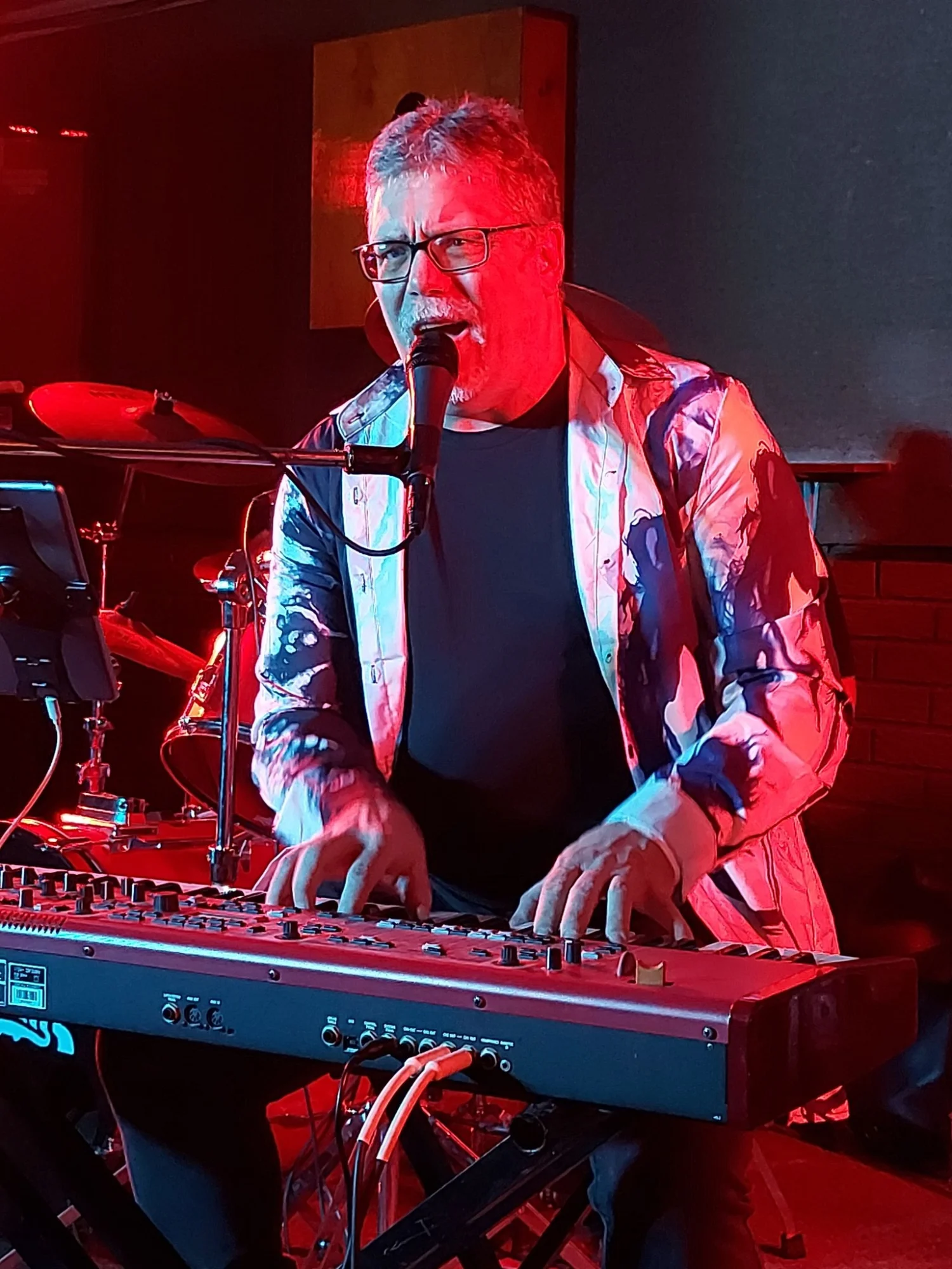 Roy performing with red stage lighting